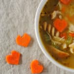 heart shaped carrots and a bowl of chicken soup