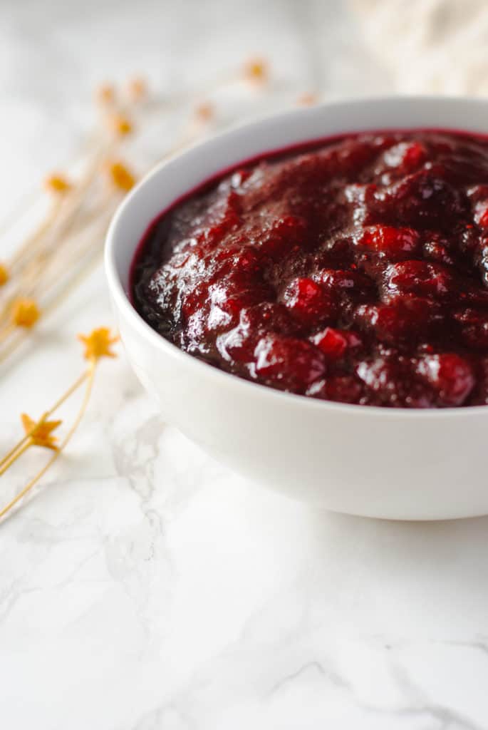 Cranberry sauce in a bowl on a marble background