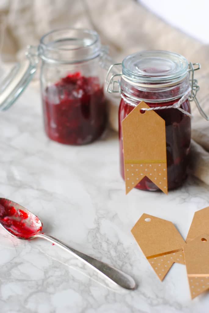 Small jars of spiced cranberry sauce with gift tags