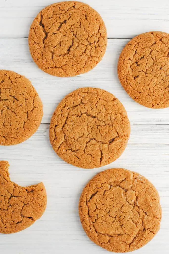 ginger cookies on white background, one with a bite taken