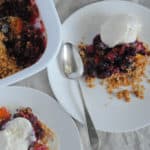 Summer fruit crisp of blackberries, peaches, and plums topped with vanilla ice cream