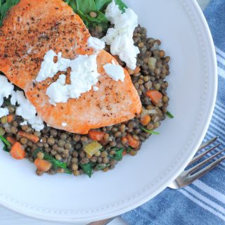 plate of lentils and spinach with salmon topped with goat cheese