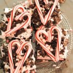 squares of peppermint surprise ice cream dessert topped with crushed oreos and candy cane in heart shape