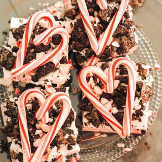 squares of peppermint surprise ice cream dessert topped with crushed oreos and candy cane in heart shape