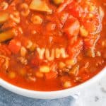 alphabet soup with pasta spelling yum in a white bowl